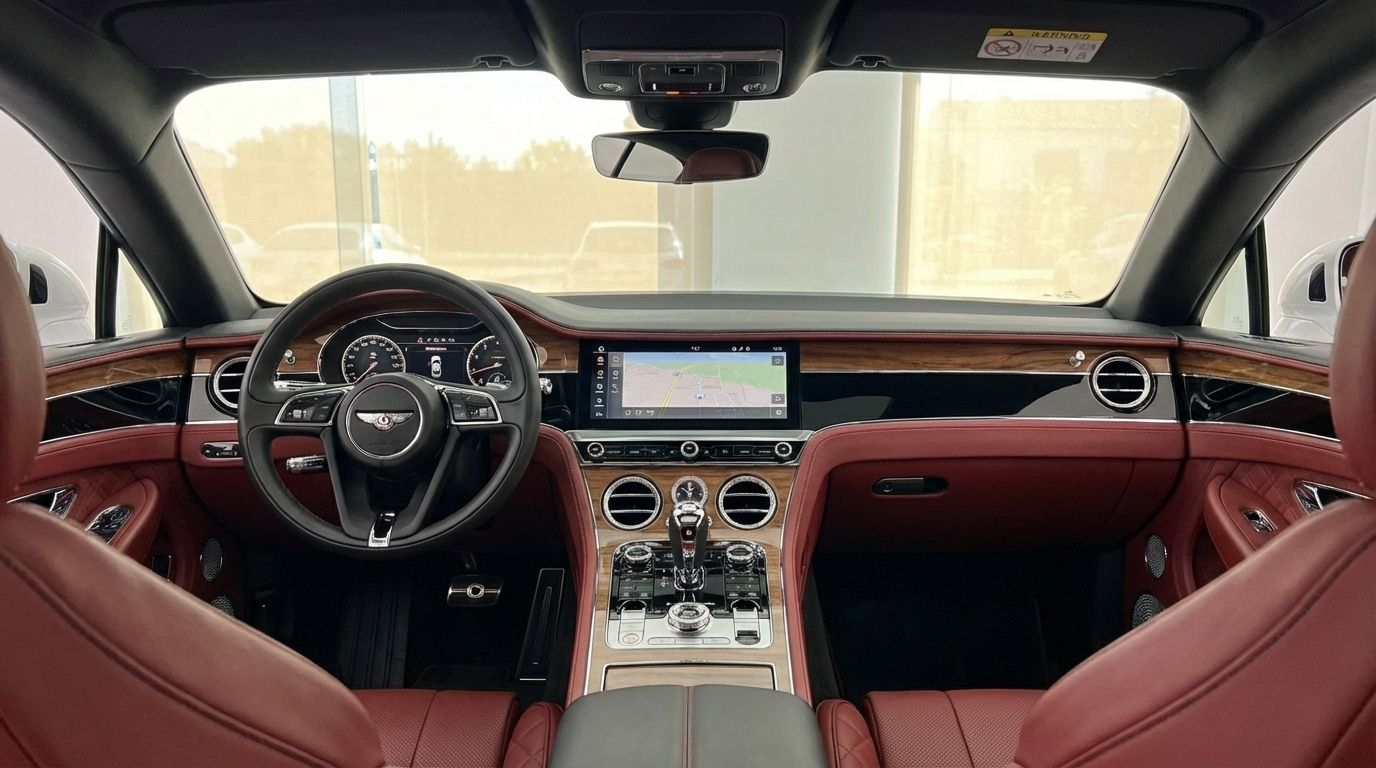The luxurious interior of the Bentley Continental GTC in Barcelona, featuring a detailed dashboard, steering wheel, and red leather seats.