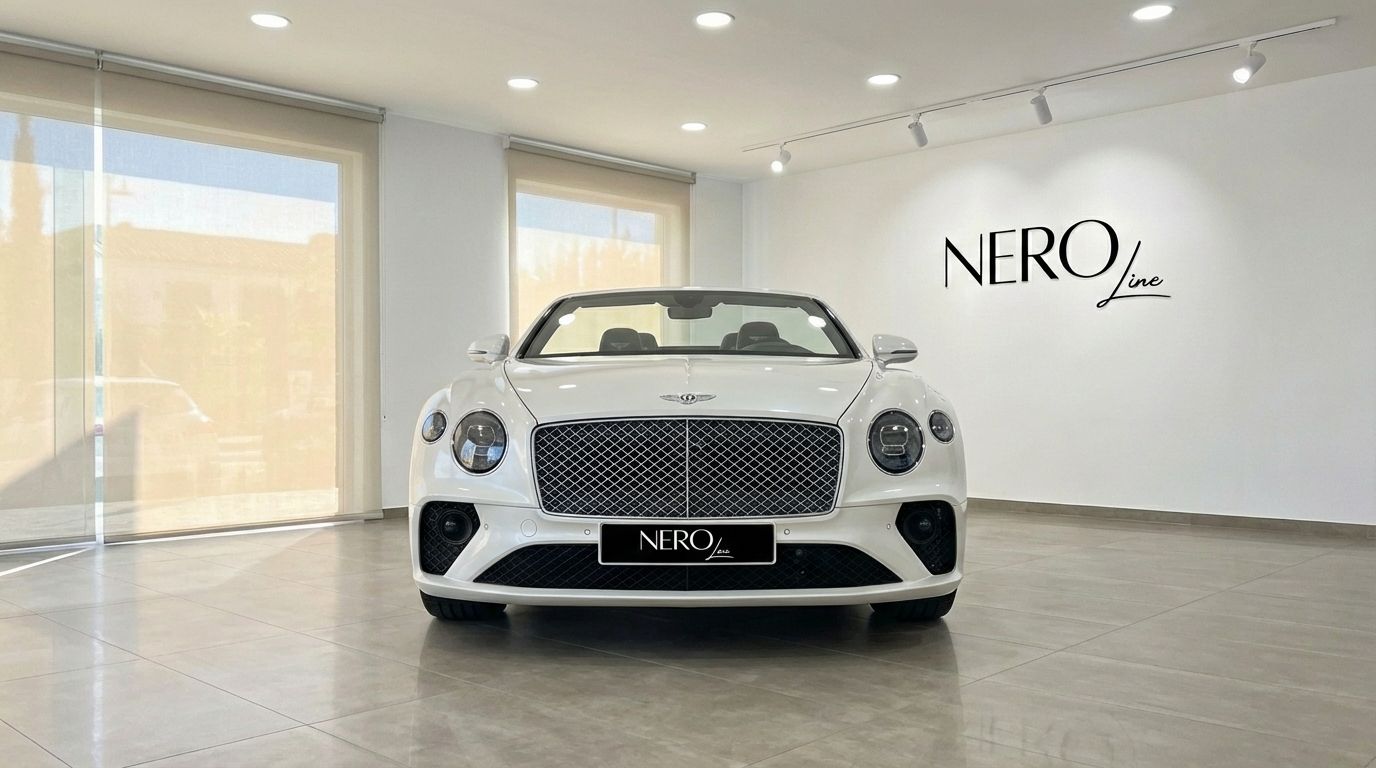 The white Bentley Continental GTC convertible is showcased from the front in a modern, well-lit showroom in Barcelona.