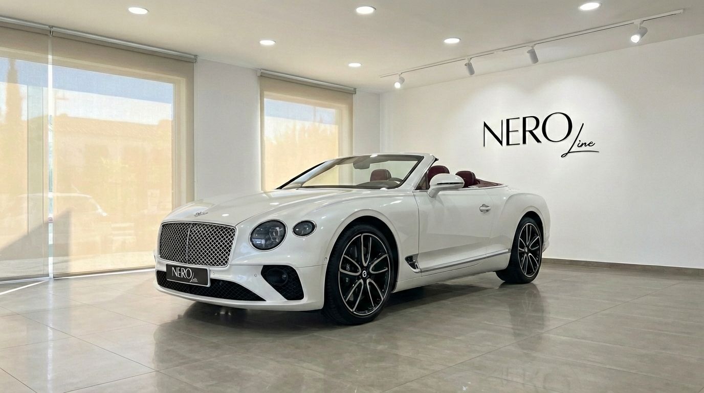 The pearl white 2020 Bentley Continental GTC convertible, with its top down and red interior, is showcased in a Barcelona showroom.