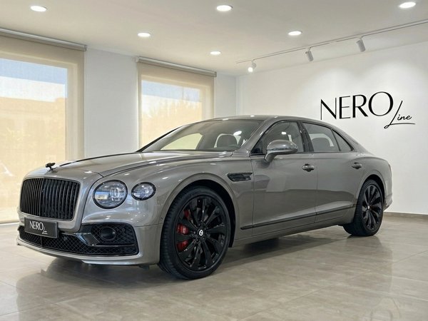 Bentley Flying Spur Special — Luxury sedan in Marbella The metallic gray Bentley Flying Spur Special is parked indoors, shown from a front three-quarter angle in Marbella.