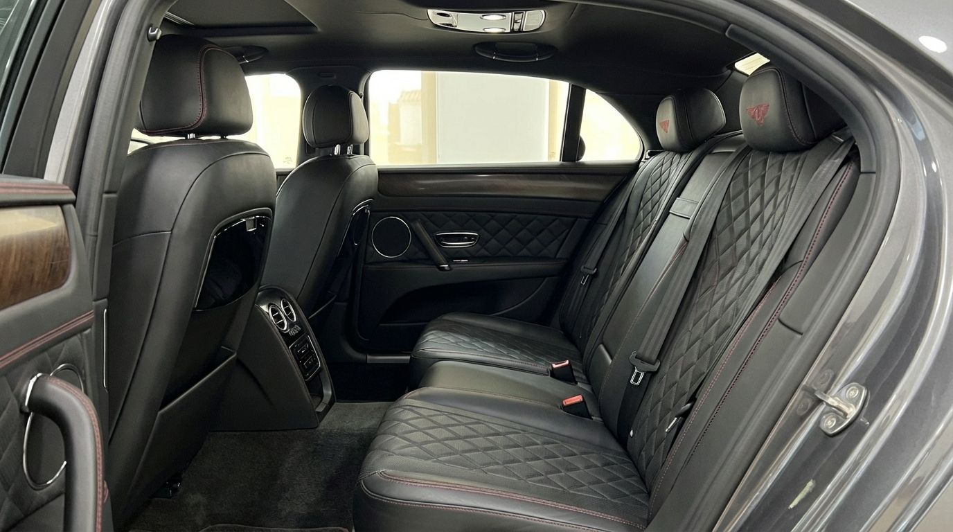 The Bentley Flying Spur Special's luxurious rear interior in Marbella features quilted black leather seats with red stitching and wood trim.