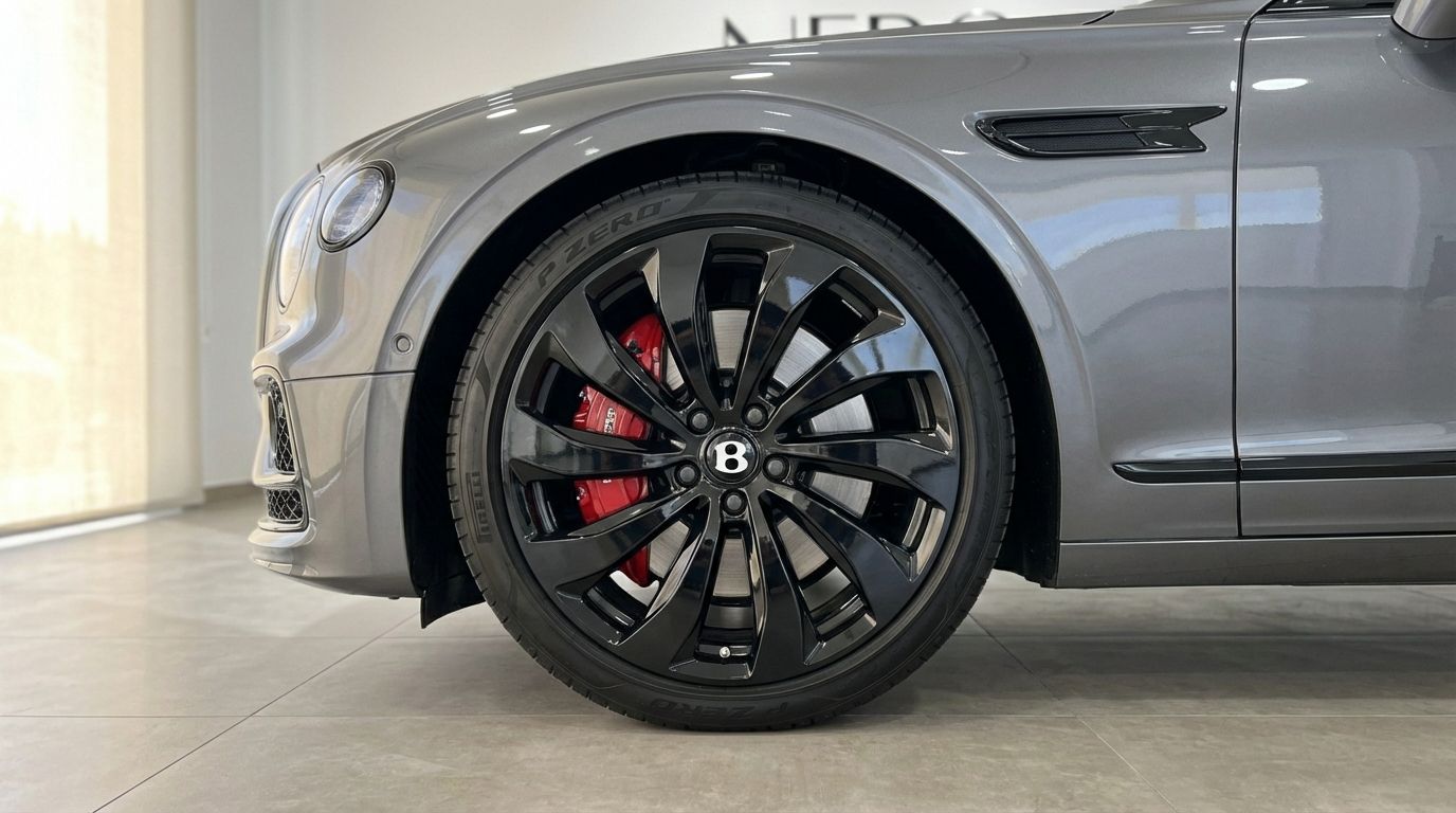 Close-up of the Bentley Flying Spur Special's metallic gray front, showcasing its black multi-spoke wheel with red calipers in Marbella.