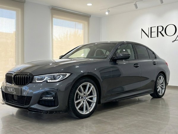 BMW 320d — Front three-quarter view Alicante The dark grey BMW 320d is showcased in a front three-quarter view within a bright showroom in Alicante.