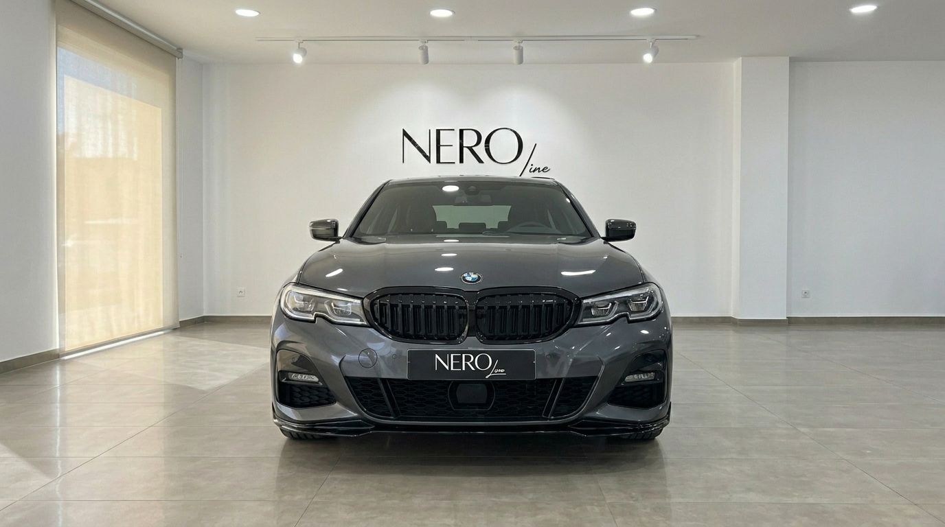 The dark grey BMW 320d is prominently displayed from the front in a bright showroom featuring the NEROline logo on the wall in Alicante.