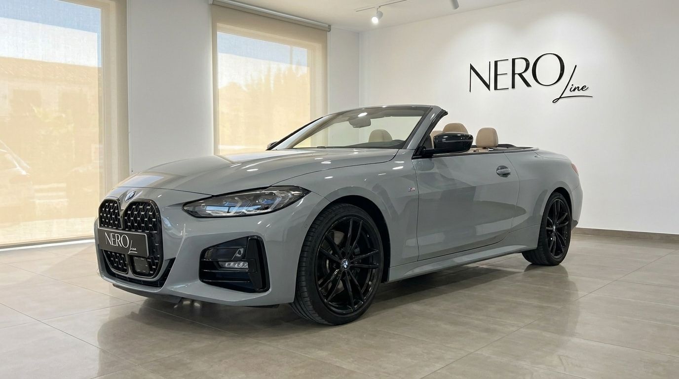 The metallic Brooklyn Grey BMW 420d Cabriolet, with its top down and tan interior, is showcased in a Marbella showroom.