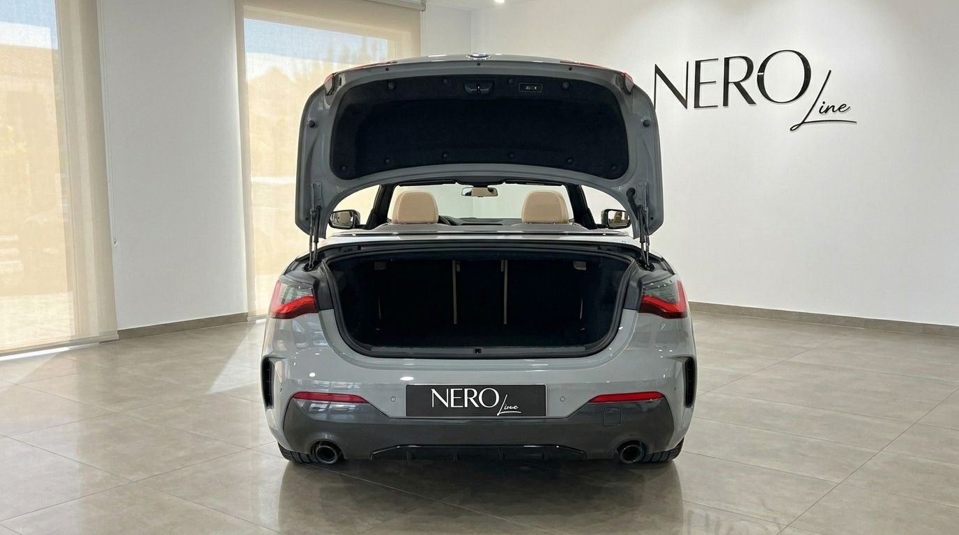 The metallic Brooklyn Grey BMW 420d Cabriolet is shown from the rear with its trunk open, revealing the beige interior seats in Marbella.
