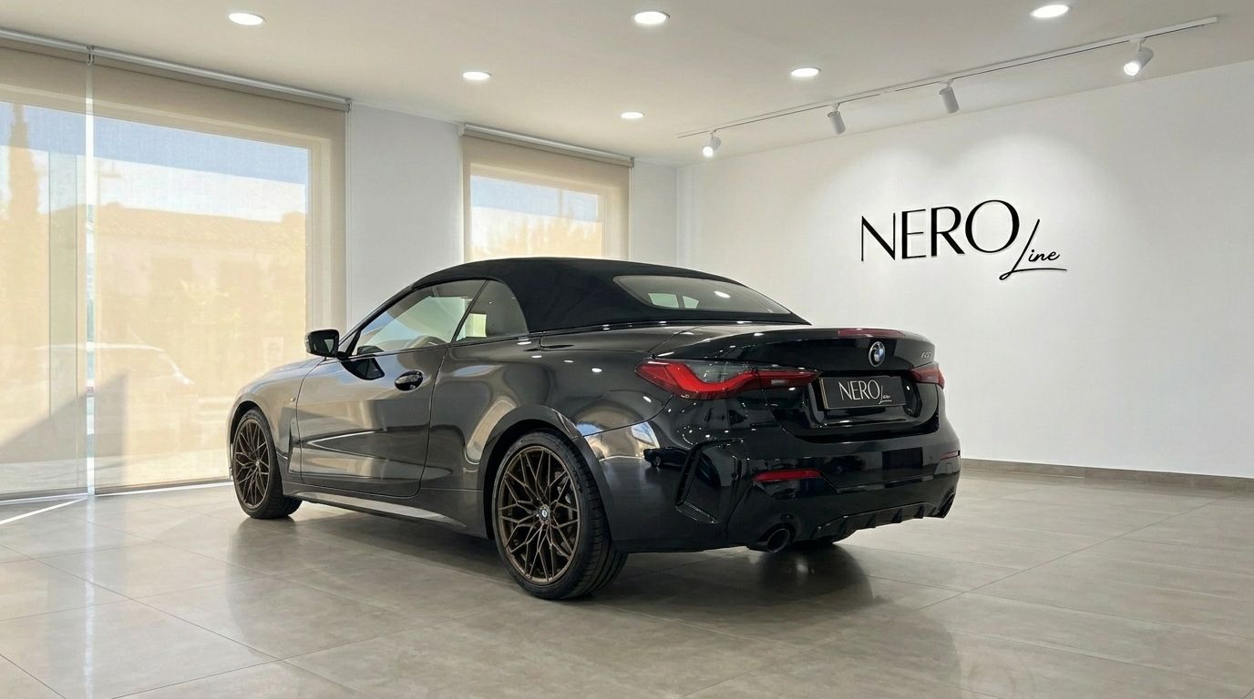 The 2023 BMW 430i M Convertible in gloss black is showcased from a rear three-quarter angle in Benidorm.
