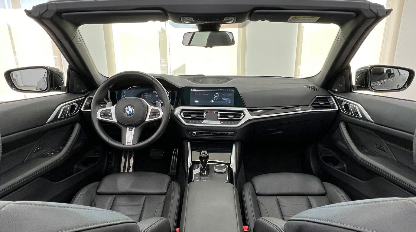The luxurious cockpit of the 2023 BMW 430i M Convertible, showcasing the dashboard, steering wheel, and black leather seats, available in Benidorm.