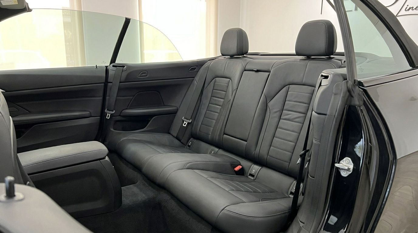 The luxurious black leather rear seats and interior of the BMW 430i M Convertible are visible in Benidorm.