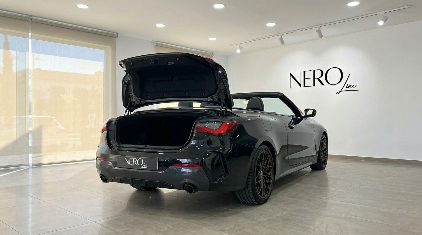 The black 2023 BMW 430i M Convertible is shown from the rear with its trunk open and soft top down in Benidorm.