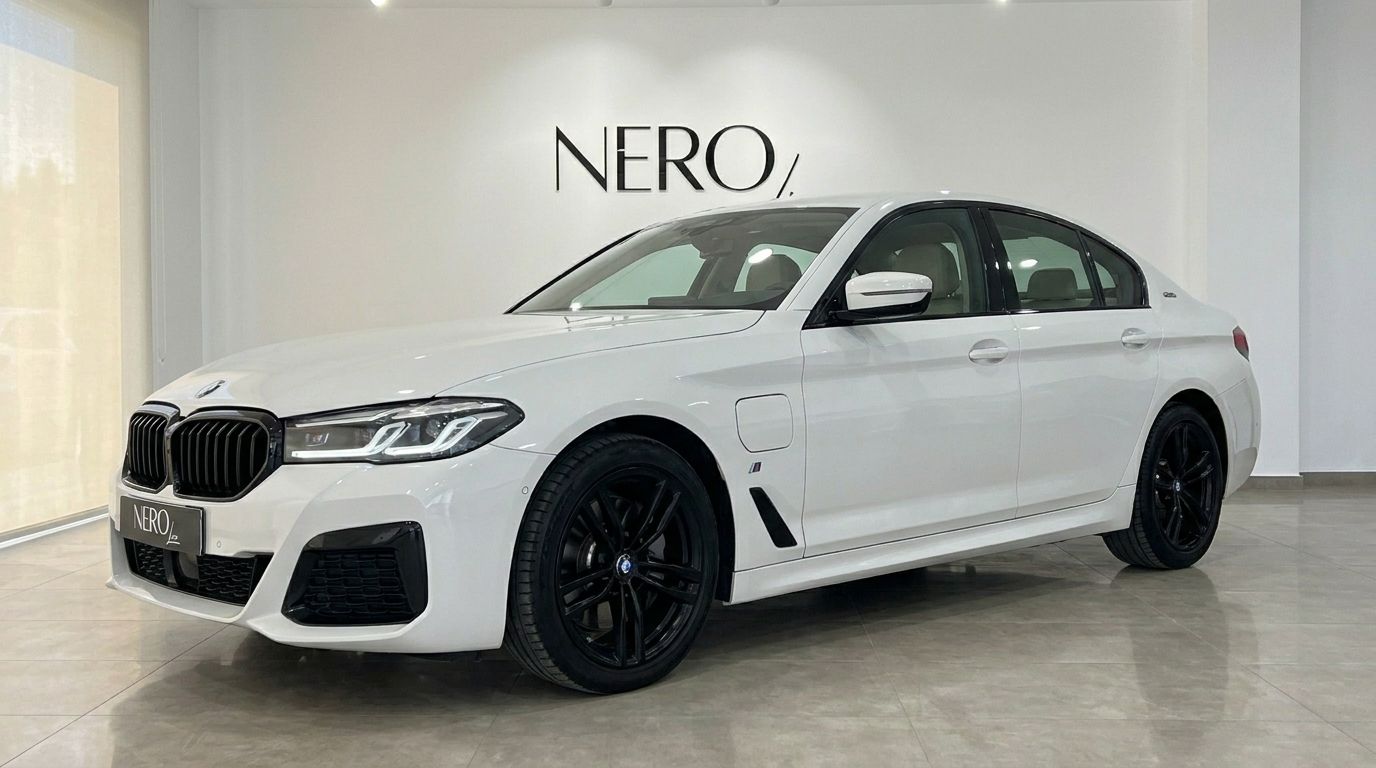 The white BMW 530e xDrive luxury sedan is shown from a front three-quarter angle with black wheels in an Alicante showroom.