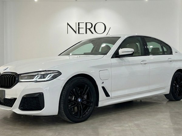 BMW 530e xDrive — Front three-quarter view Alicante The white BMW 530e xDrive luxury sedan is shown from a front three-quarter angle with black wheels in an Alicante showroom.