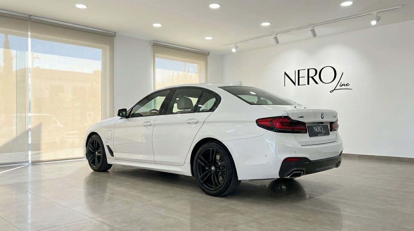 White BMW 530e xDrive sedan parked in a showroom in Alicante, shown from a rear three-quarter angle.