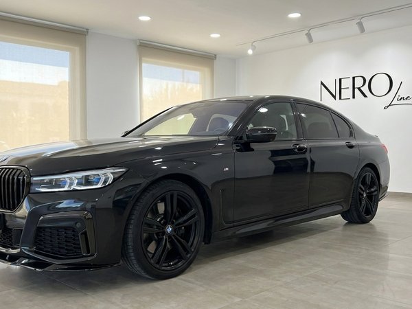 BMW 730 — Luxury Sedan in Alicante Showroom Black BMW 730 luxury sedan displayed in a showroom with the Nero Line logo on the wall in Alicante.