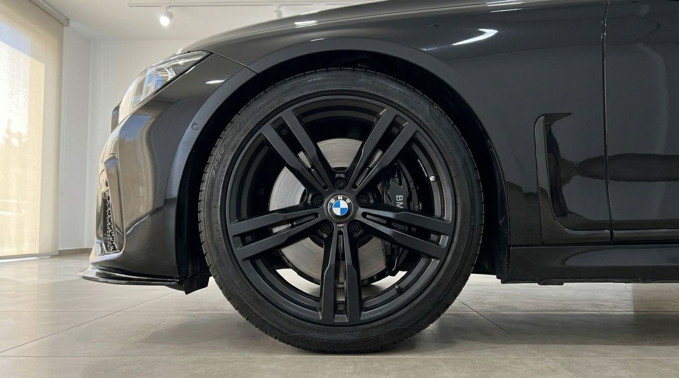 The BMW 730's sleek black front wheel with its distinctive multi-spoke rim and brake caliper is prominently displayed in Alicante.