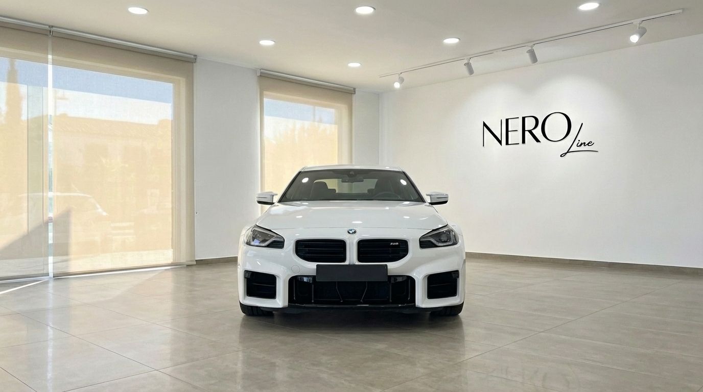 El BMW M2 Competition blanco de 2025 se exhibe desde una vista frontal directa dentro de un luminoso showroom en Madrid.