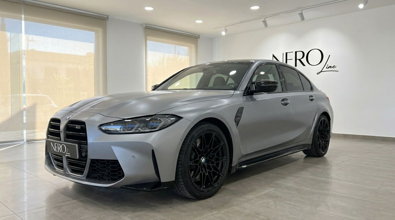 The 2023 BMW M3 Competition xDrive in Matte Frozen Pure Grey, shown from a front three-quarter view in a Marbella showroom.
