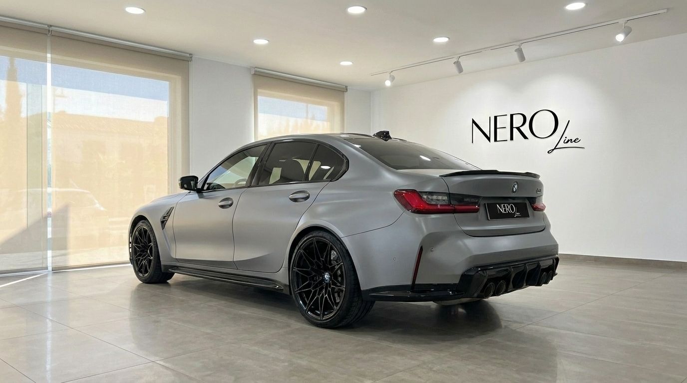 The Matte Frozen Pure Grey BMW M3 Competition xDrive is showcased from a rear three-quarter angle in a Marbella showroom.