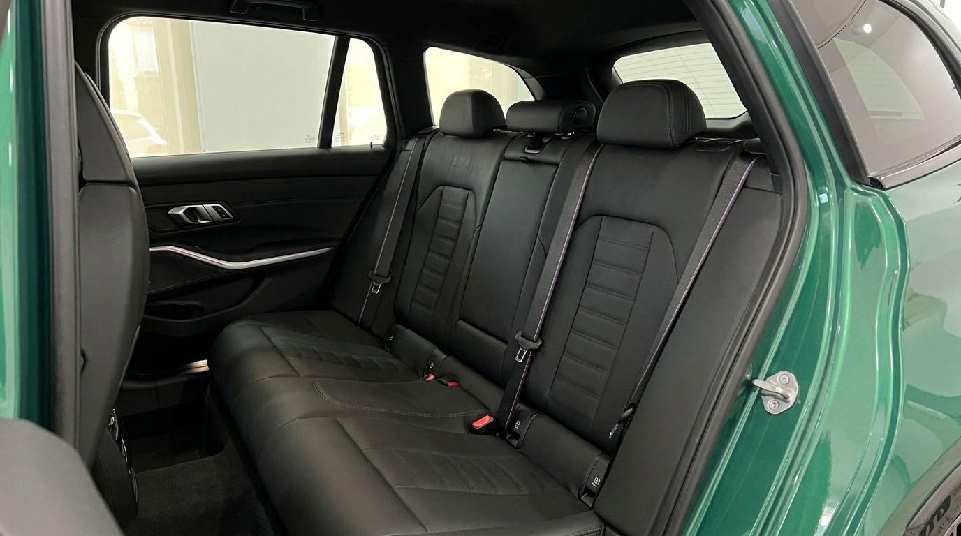 The luxurious black leather rear seats of the BMW M3 Touring Competition xDrive are visible from the open door in Marbella.