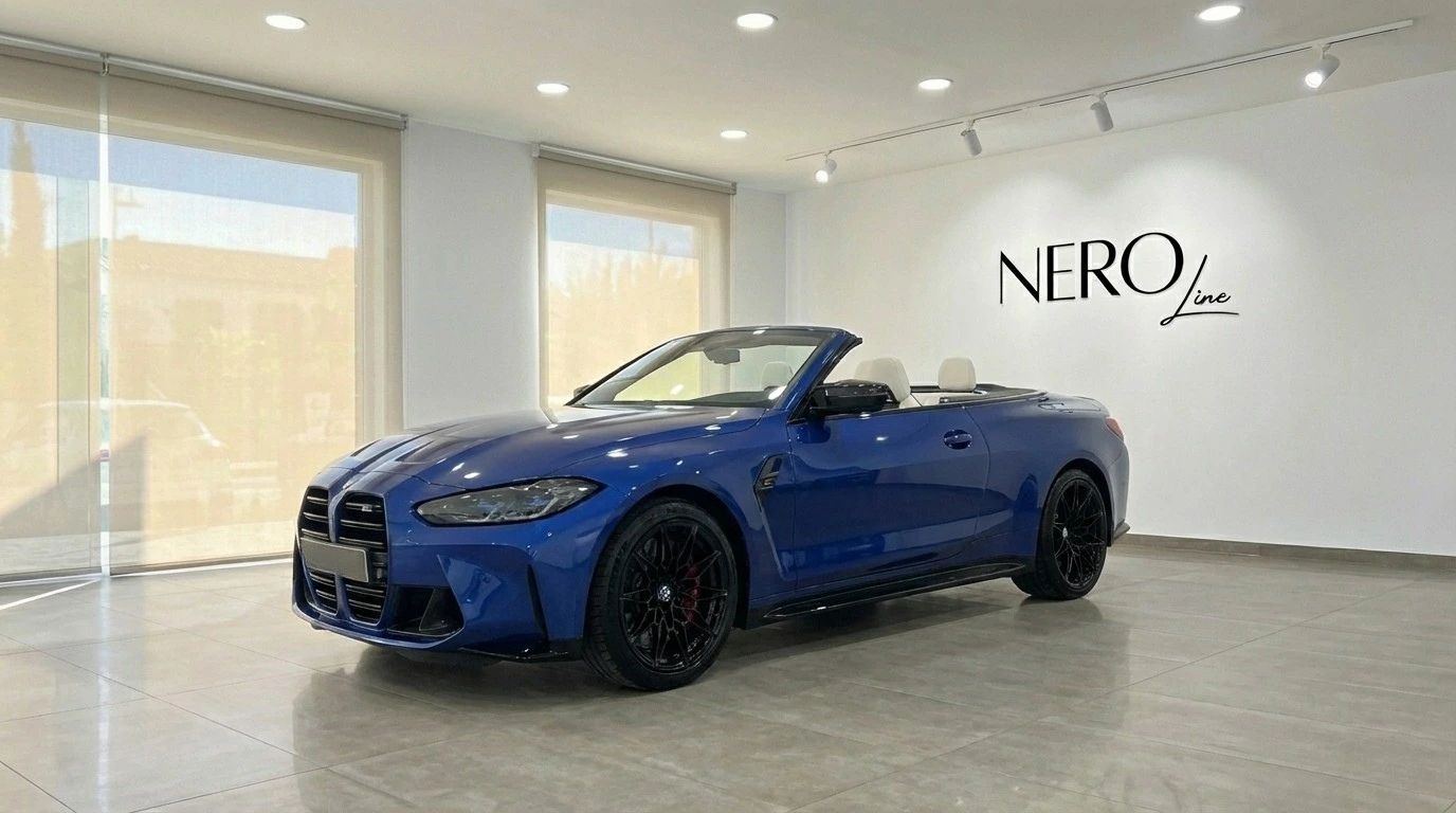 The metallic blue 2025 BMW M4 Competition Convertible, with its top down and white interior, is showcased in a Barcelona showroom.