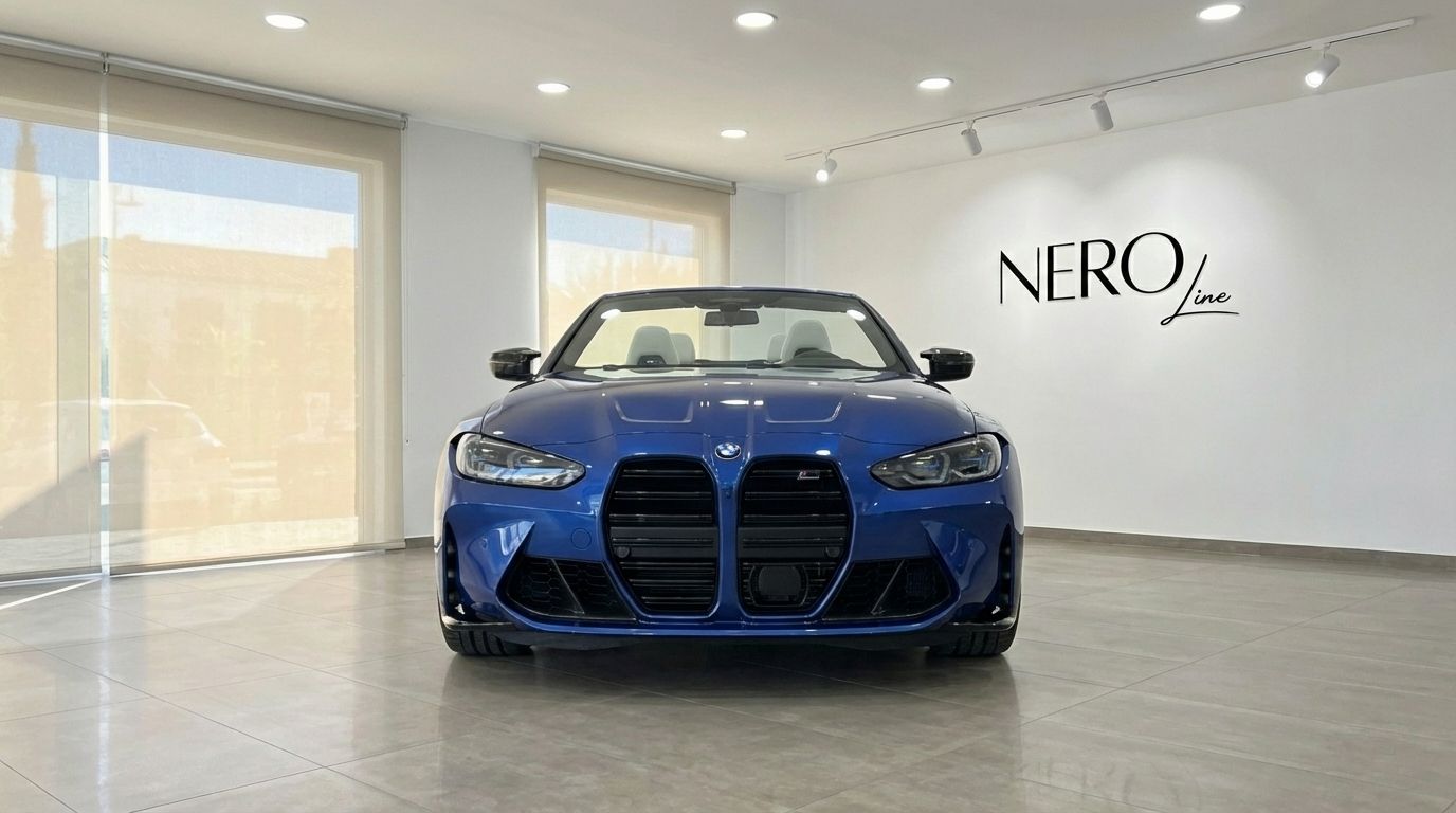 The metallic blue BMW M4 Competition Convertible is showcased from a front view in a Barcelona showroom, top down, revealing its luxurious interior.