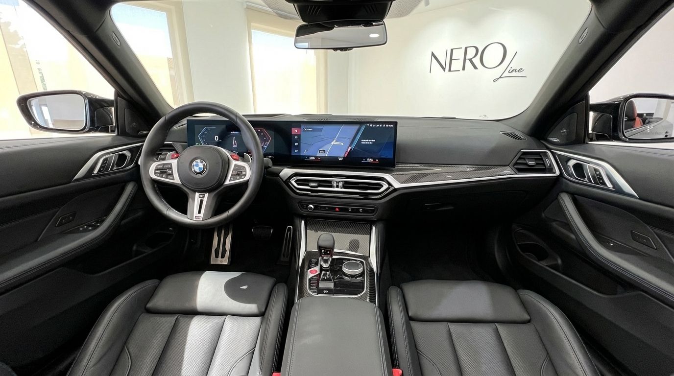 El lujoso interior del BMW M4 Competition Convertible 2025 en Madrid, mostrando el moderno salpicadero, volante y asientos de cuero negro.