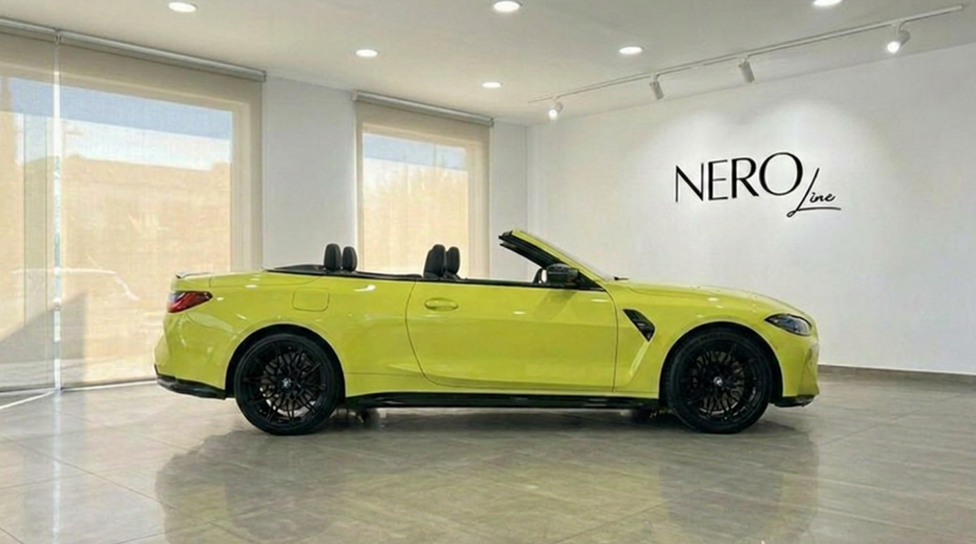 BMW M4 Competition Convertible xDrive jaune Sao Paulo brillant, vue de côté, capote ouverte, exposée en intérieur à Marbella.