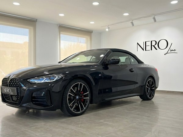 BMW M440i Cabrio — Vista en showroom Madrid Un elegante BMW M440i Cabrio negro de 2023 con la capota puesta, aparcado en un moderno concesionario en Madrid.