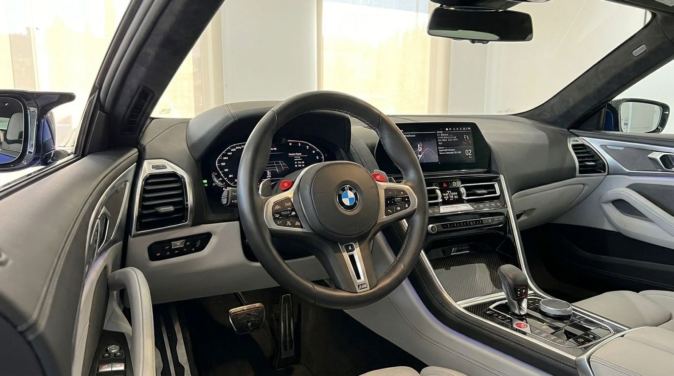 The luxurious interior of the BMW M8 Competition Gran Coupe in Marbella, highlighting the steering wheel, dashboard, and infotainment.