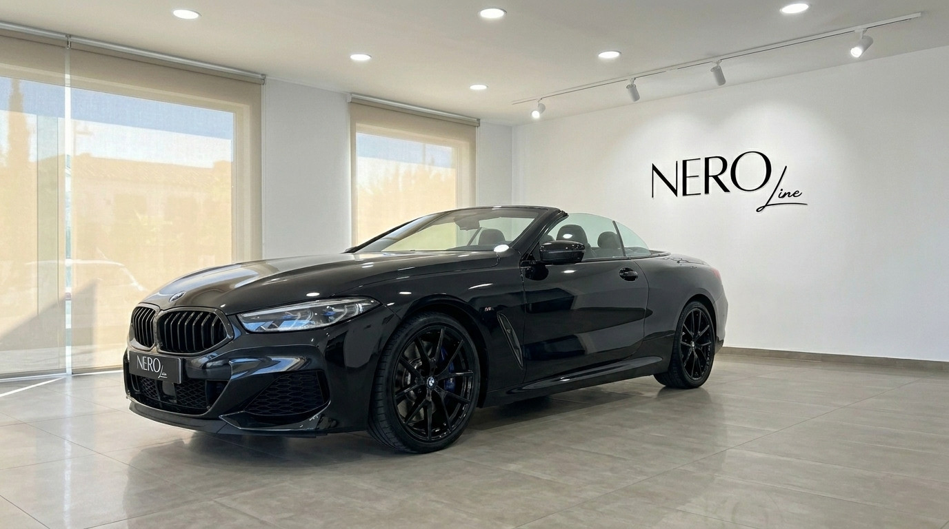 BMW M850 Convertible — Showroom in Alicante The sleek gloss black 2021 BMW M850 convertible is showcased with its top down in a bright showroom in Alicante, offering a luxurious front three-quarter view.
