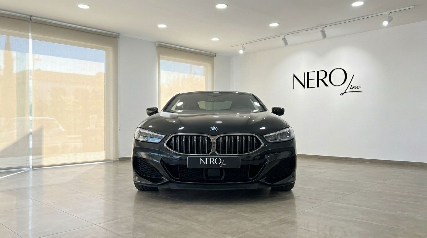The sleek black 2021 BMW M850 is prominently displayed from a front view in a bright showroom in Alicante.