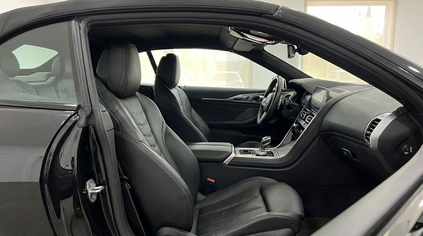 The luxurious black leather interior of the BMW M850 in Alicante, showcasing the driver's seat, dashboard, and steering wheel.