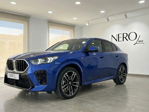 BMW X2 — Luxury Car Rental in Alicante The blue 2025 BMW X2 is prominently displayed in a showroom, captured from a front three-quarter angle in Alicante.