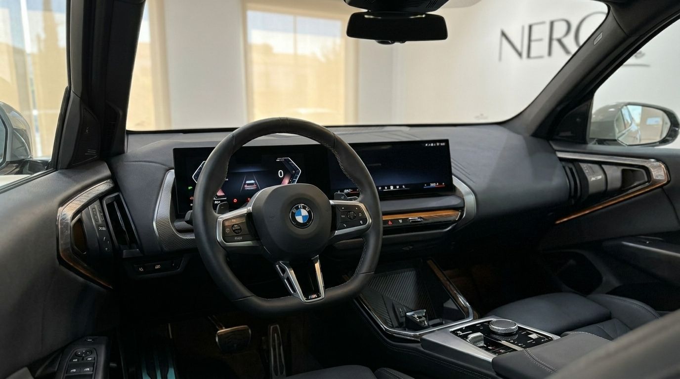 The luxurious cockpit of the BMW X3 2.0 Diesel in Alicante, featuring the steering wheel, digital dashboard, and sleek center console.