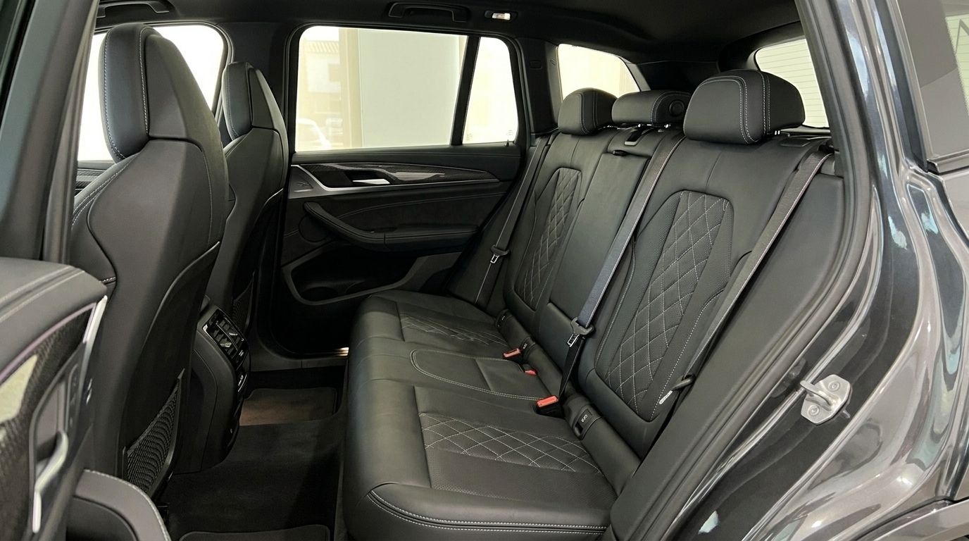 I sedili posteriori in pelle nera con cuciture a diamante bianche e poggiatesta sono visibili all'interno della BMW X3 M50D ad Alicante.