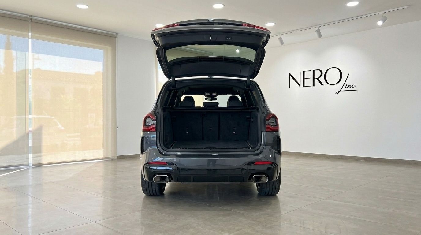 La vista posteriore della BMW X3 M50D, che mostra il suo spazioso bagagliaio aperto in un moderno showroom ad Alicante, Spagna.