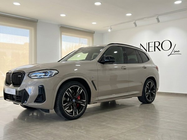 BMW X3 M50i xDrive — Front three-quarter view The Gloss Dune Grey 2025 BMW X3 M50i xDrive is shown from a front three-quarter angle in a showroom in Marbella.