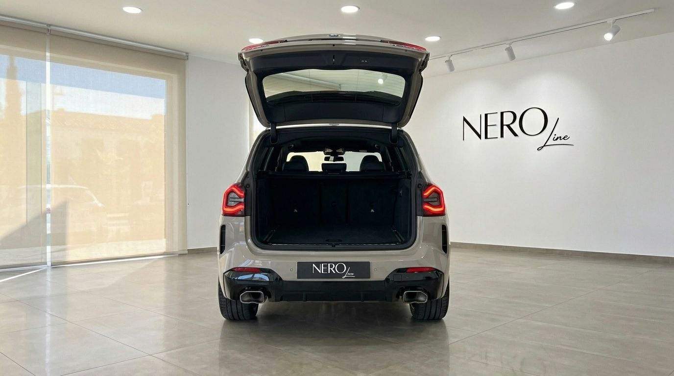 Rear view of the Gloss Dune Grey BMW X3 M50i xDrive with its open trunk, showcasing the spacious cargo area.