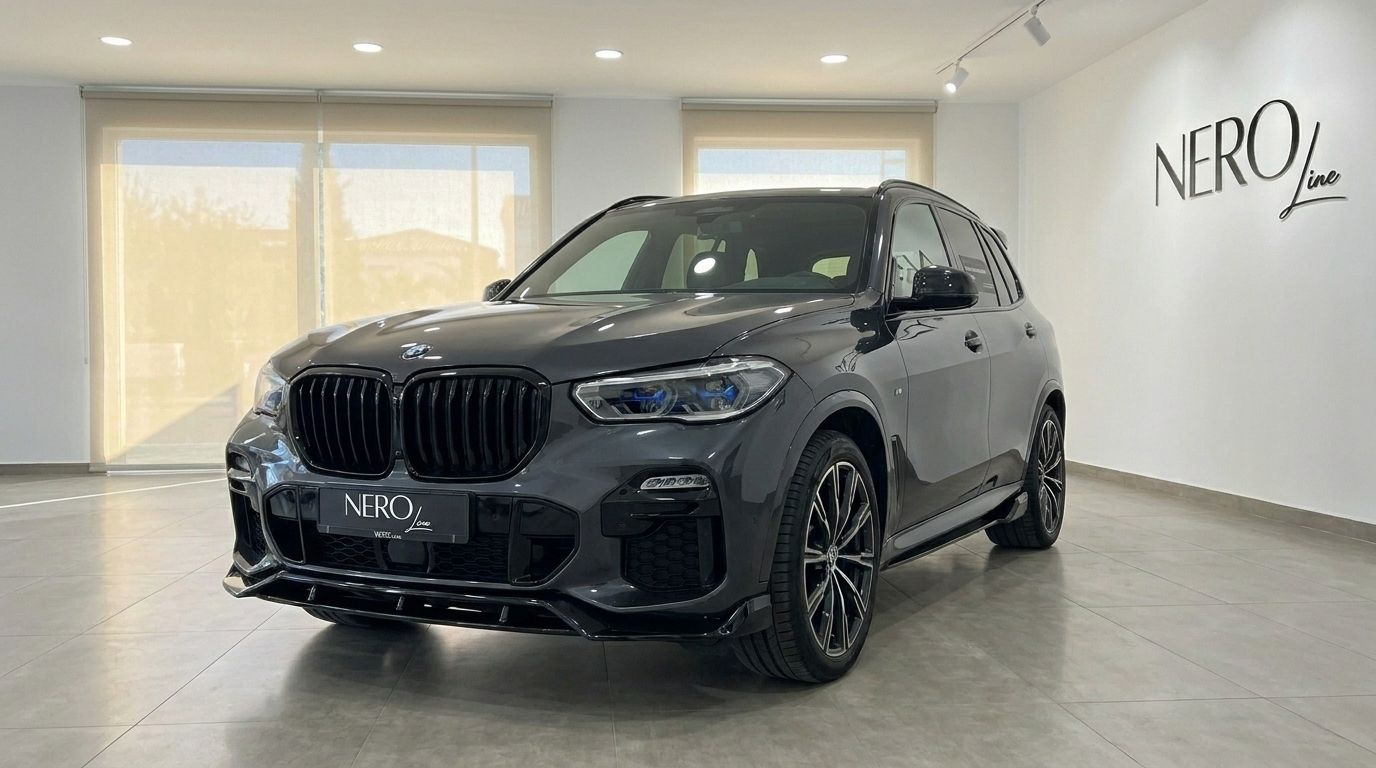 The dark grey BMW X5 xDrive45e is prominently displayed from a front three-quarter angle inside a modern showroom in Alicante.