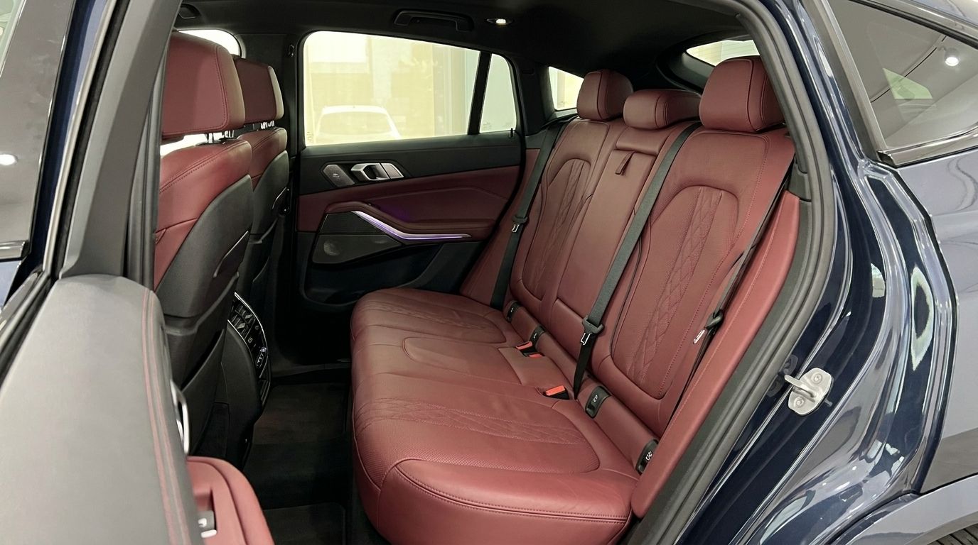 The luxurious red leather rear seats and interior of the BMW X6 are visible from the open door in Alicante.