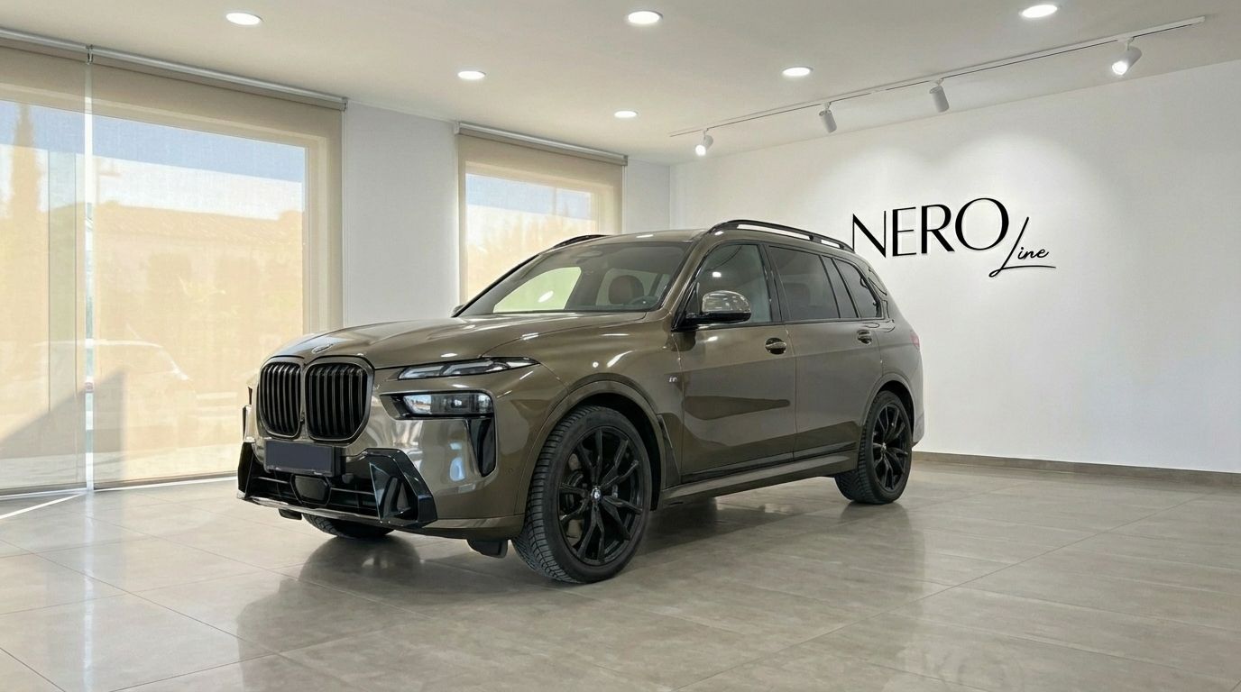 The dark olive green BMW X7 3.0d luxury SUV is presented from a front three-quarter angle, parked indoors in Alicante.