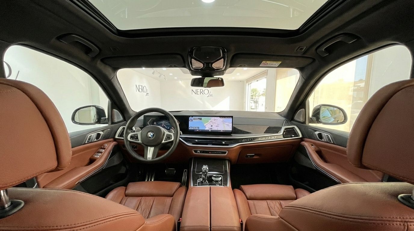 The luxurious interior of the 2024 BMW X7 3.0d in Alicante, showcasing its brown leather seats, modern dashboard, and panoramic sunroof.