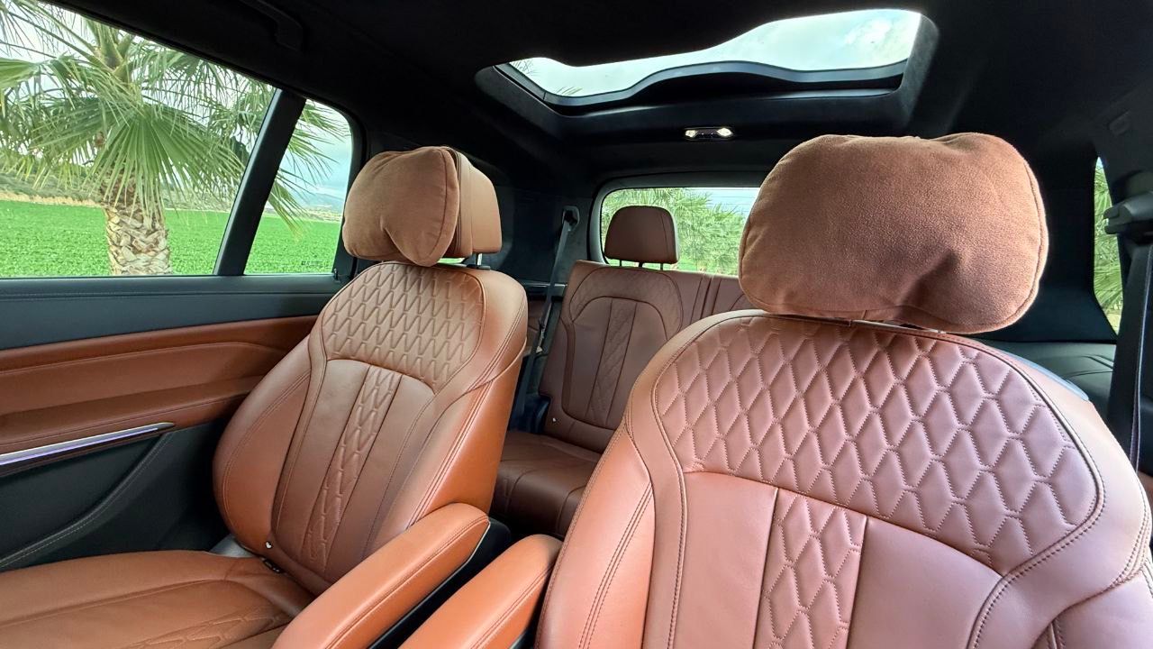 BMW X7 3.0d luxurious brown leather interior with quilted stitching, panoramic roof, and rear seats visible in Alicante.