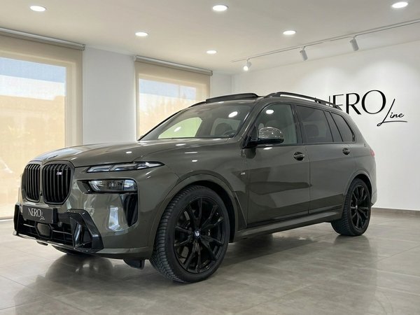 BMW X7 — Front three-quarter view in showroom Dark grey BMW X7 SUV, front three-quarter view, parked in a modern showroom in Alicante.