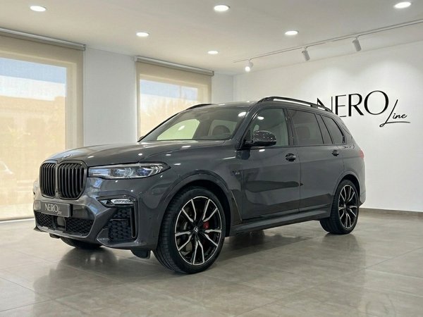 BMW X7 M50i — Front three-quarter view in Benidorm The gloss dark grey 2021 BMW X7 M50i is showcased from a front three-quarter view in a Benidorm showroom.