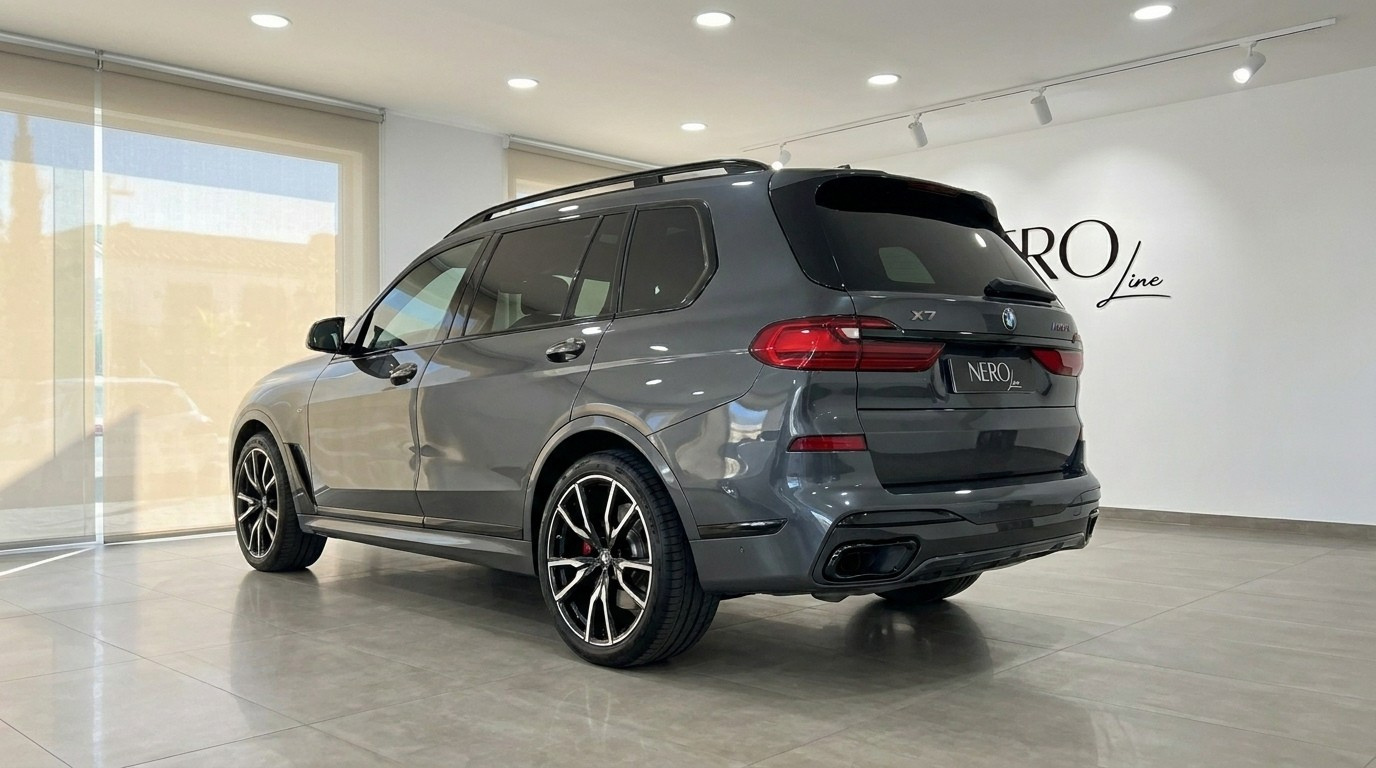 The Gloss Dark Grey BMW X7 M50i is shown from a rear three-quarter angle in a bright Benidorm showroom.