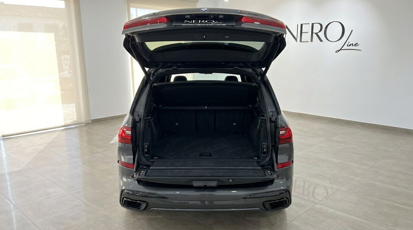The rear view of the Gloss Dark Grey BMW X7 M50i, showcasing its spacious open trunk, available for rental in Benidorm.