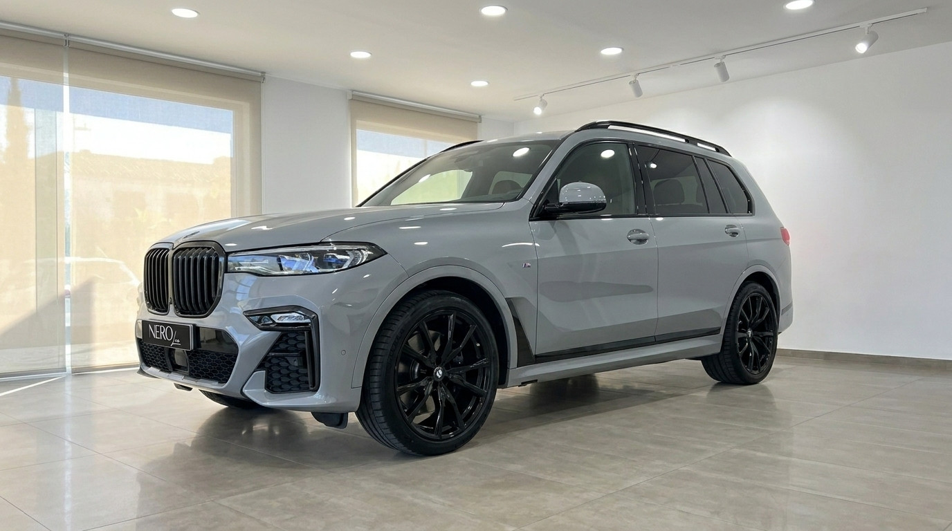 BMW X7 xDrive M Sport — Front three-quarter view The grey BMW X7 xDrive M Sport, featuring black wheels, is showcased from a front three-quarter view indoors in Marbella.