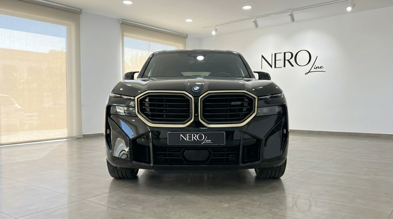 The 2025 BMW XM in Gloss Black is prominently displayed from a front view in a showroom in Alicante.