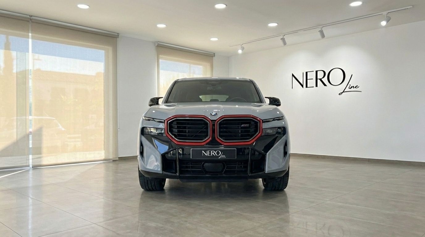El BMW XM Label Red 2023 gris claro con detalles rojos se muestra de frente en un concesionario de Madrid.